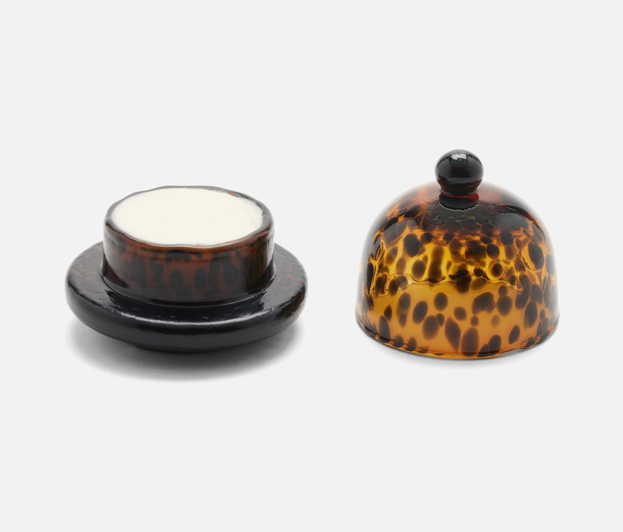 Andrew Tortoise Round Butter Dish made from hand-blown glass with a rich Tortoise finish. Measures 3 inches in diameter and 3 inches in height, adding a touch of elegance to any table. Dishwasher safe with unique variations.