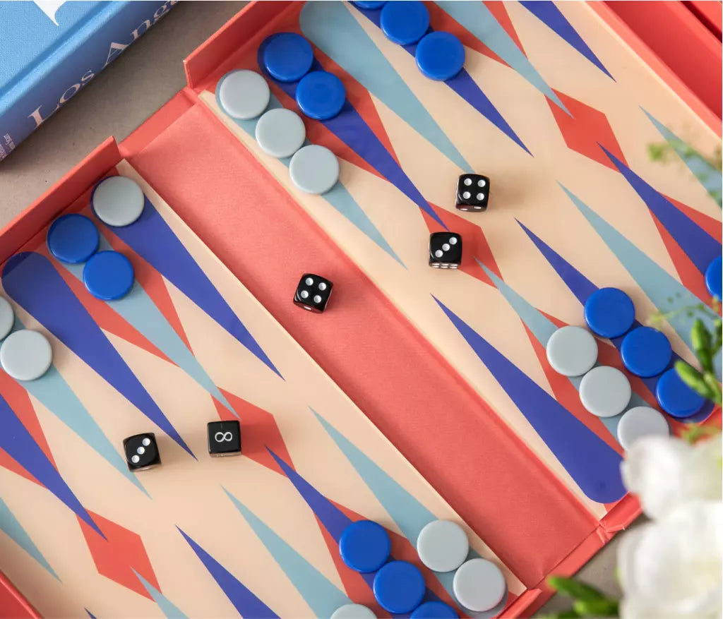 Modern Backgammon set with bold red and blue design, housed in a book-like box with an acrylic board and instructions in English, French, and German. Suitable for 2 players, ages 5+, and perfect for play or display.