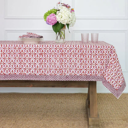 Fleur de Lis Rose Tablecloth with a soft pink pattern and bold purple border, hand-block printed on 100% cotton. Perfect for adding elegance to your dining table. Measures 60" x 120".