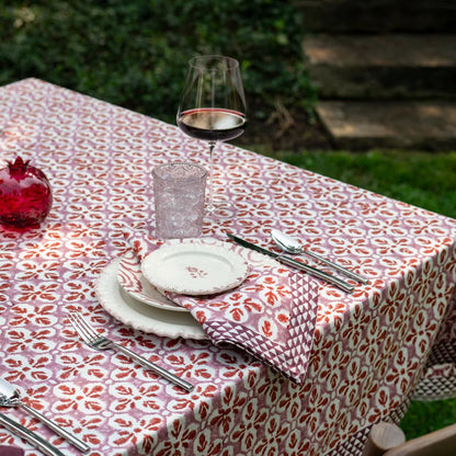 Fleur de Lis Rose Tablecloth with a soft pink pattern and bold purple border, hand-block printed on 100% cotton. Perfect for adding elegance to your dining table. Measures 60" x 120".