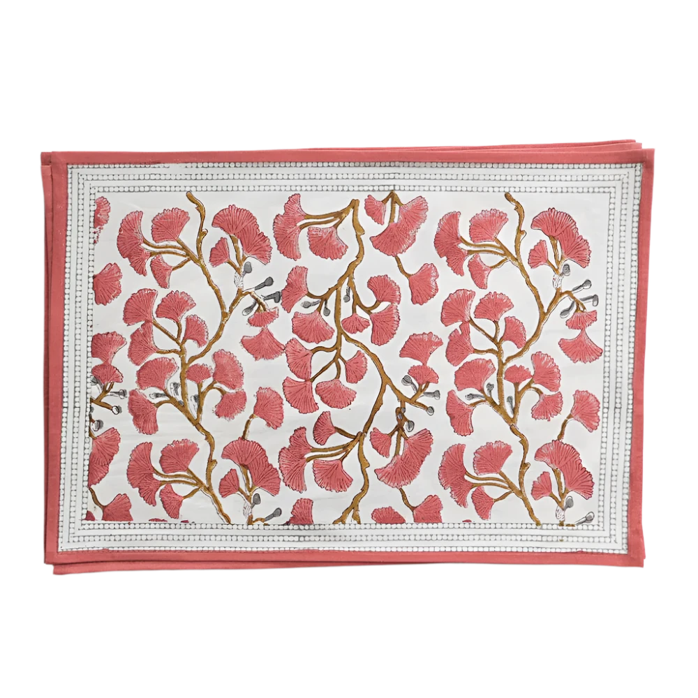 Set of Ginkgo Coral Placemats featuring a hand block printed coral ginkgo leaf design on soft cotton canvas. Made from 100% cotton, these placemats are machine washable and measure 13" x 19". Ideal for both casual and formal dining. Made in India.