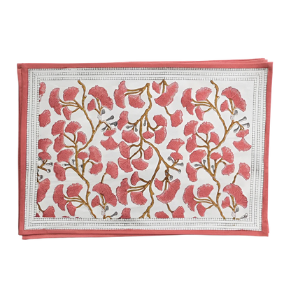 Set of Ginkgo Coral Placemats featuring a hand block printed coral ginkgo leaf design on soft cotton canvas. Made from 100% cotton, these placemats are machine washable and measure 13" x 19". Ideal for both casual and formal dining. Made in India.