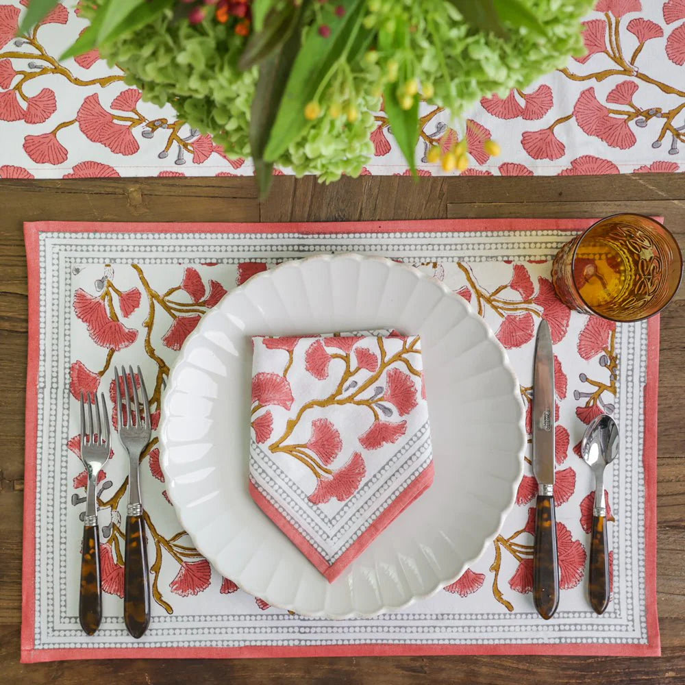 Set of Ginkgo Coral Placemats featuring a hand block printed coral ginkgo leaf design on soft cotton canvas. Made from 100% cotton, these placemats are machine washable and measure 13" x 19". Ideal for both casual and formal dining. Made in India.