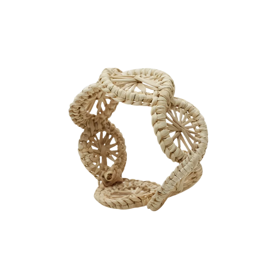 Swirl Napkin Ring, handwoven from Iraca Palm and wire by skilled artisans in Colombia. This piece adds a natural touch to your table. Clean with a damp cloth or toothbrush for best care.