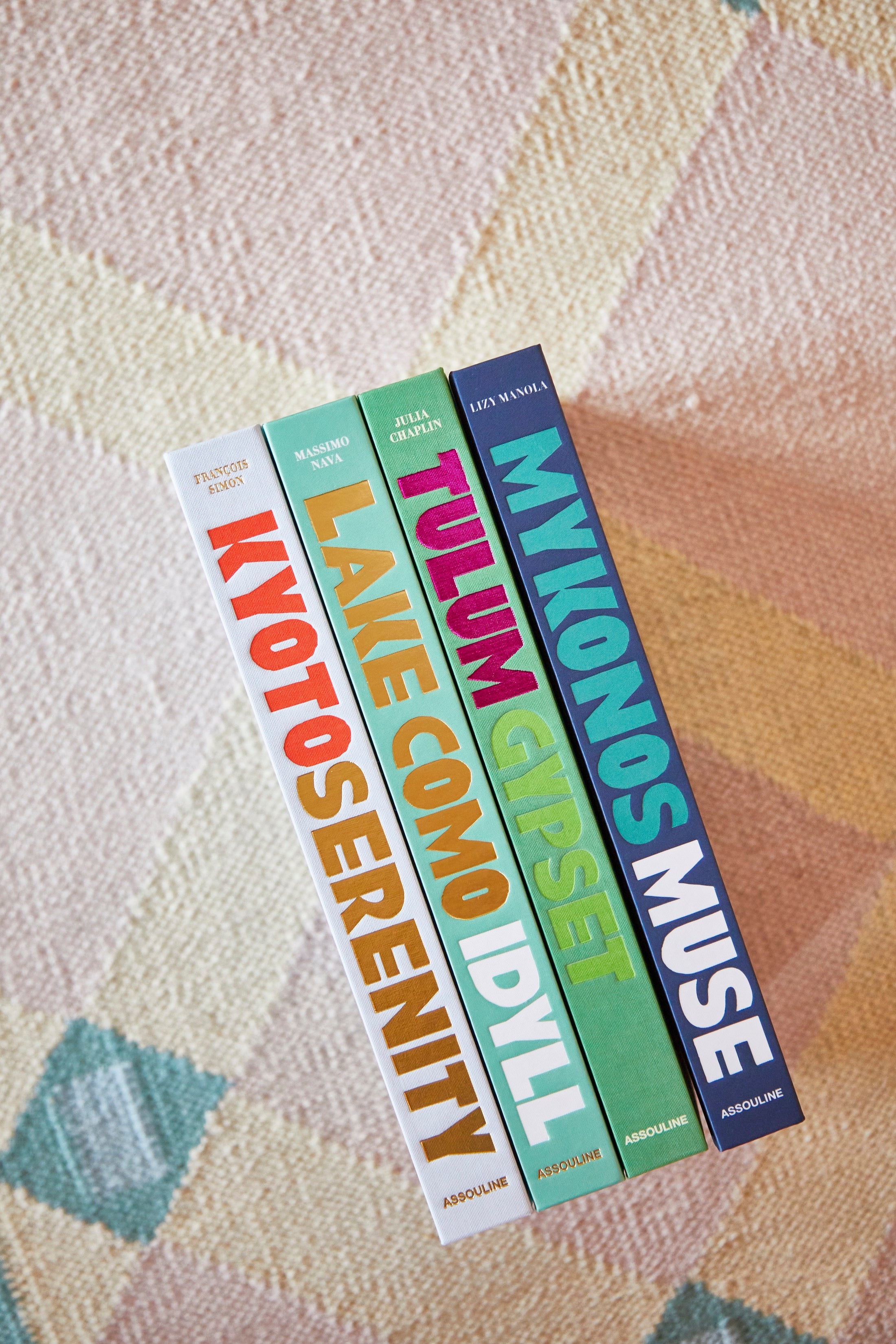 Set of travel booklets with colorful titles on a textured surface