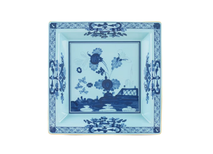 Iris square change tray in porcelain with gold threading from the Oriente Italiano collection. Features a contrasting blue carnation floral motif against iris blue porcelain with gold threading along the Antico Doccia shape.