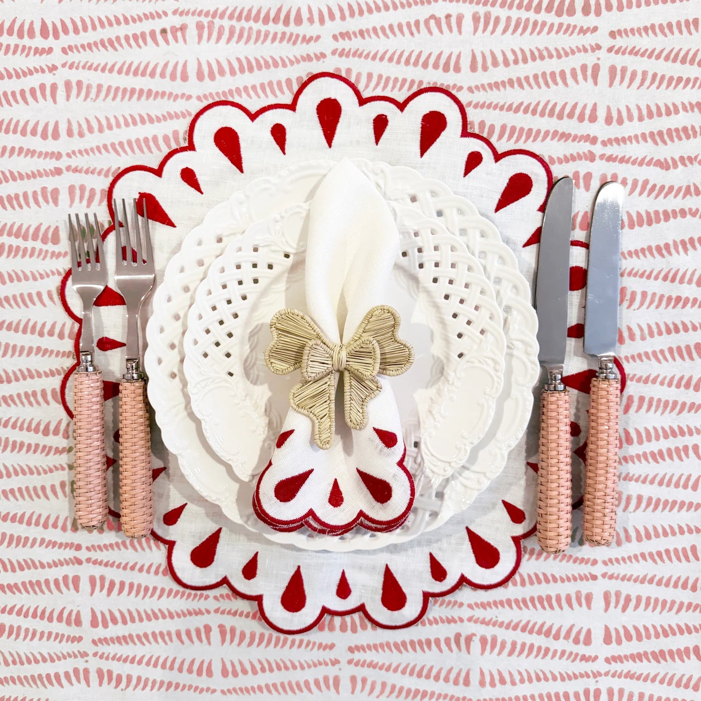 A set of 4 white linen placemats with red embroidery and scalloped edges, designed to enhance your table with a refined and elegant touch.