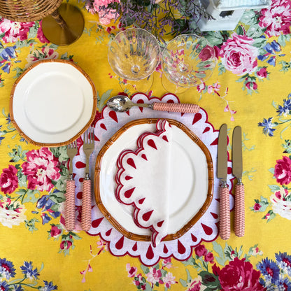 A set of 4 white linen placemats with red embroidery and scalloped edges, designed to enhance your table with a refined and elegant touch.