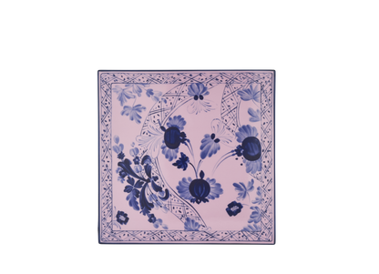 Set of 2 square porcelain placemats in Azalea from the Oriente Italiano collection, featuring a blue carnation motif with hand-painted gold threading against azalea pink porcelain