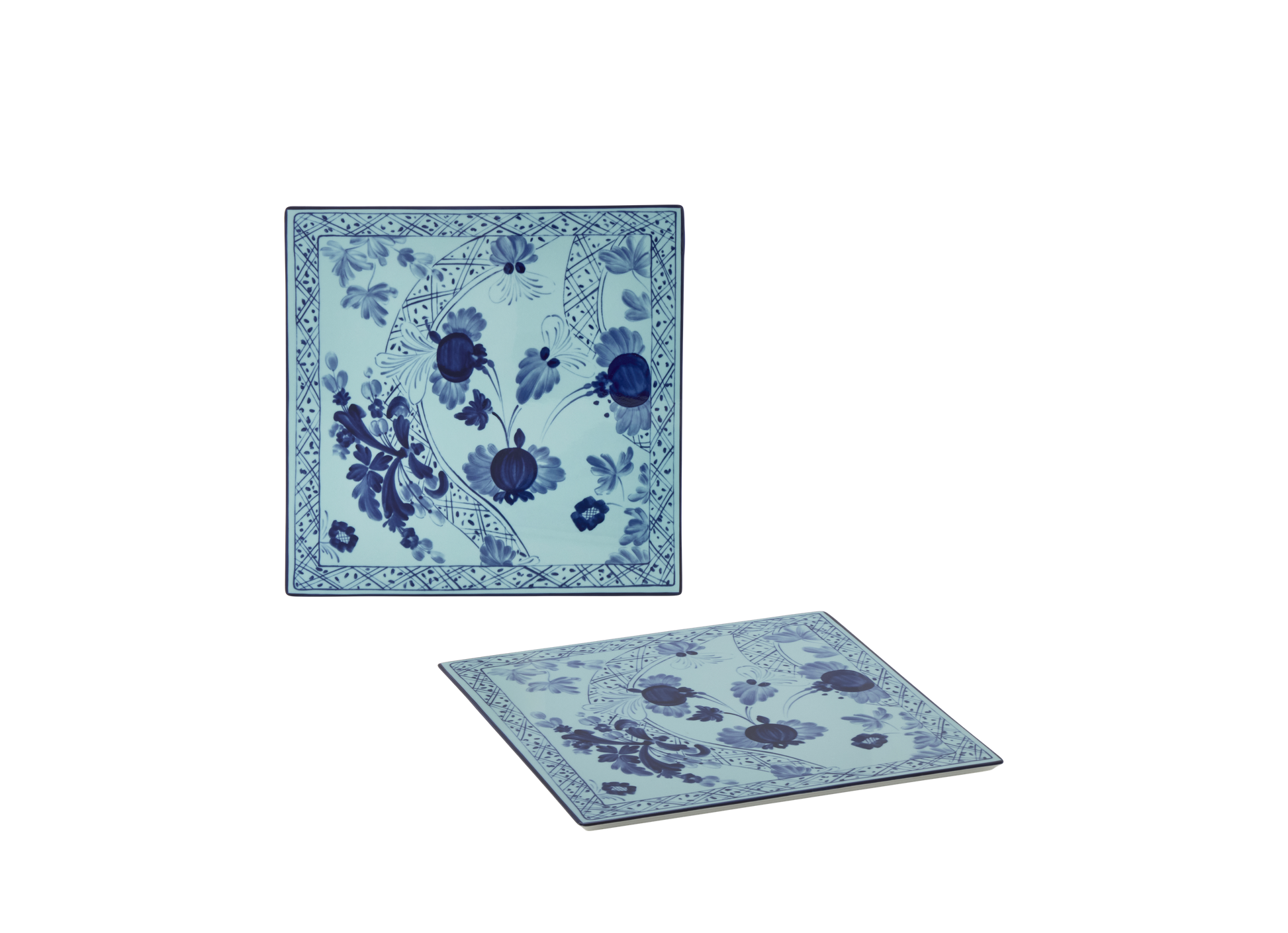 Set of 2 square porcelain placemats in Iris from the Oriente Italiano collection, featuring a blue floral pattern on an iris blue background with gold threading accents.