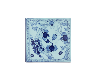 Set of 2 square porcelain placemats in Iris from the Oriente Italiano collection, featuring a blue floral pattern on an iris blue background with gold threading accents.