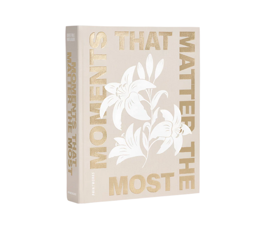 Moments that Matter the Most Coffee Table Photo Album with a beige cloth cover and gold foiled text. Includes 30 white photo paper pages for two 10x15 cm photos per page, made with FSC-certified materials and a black metal binder.