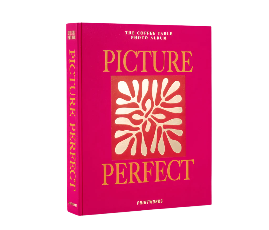 Picture Perfect Coffee Table Photo Album with a cerise cloth cover and orange text, containing 30 black photo paper pages for two 10x15 cm photos per page, with space for personal notes.