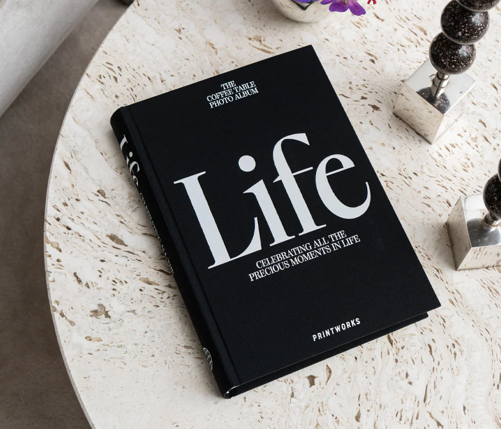 Sophisticated black photo book with 80 off-white pages for up to 160 photos, featuring expandable binding for a sleek coffee table look.