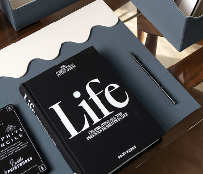 Sophisticated black photo book with 80 off-white pages for up to 160 photos, featuring expandable binding for a sleek coffee table look.