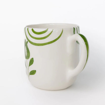 Set of 2 Pomegranate Crest Green Mugs featuring a bold hand-painted pomegranate design with delicate green arcs. Made from 100% ceramic, these mugs are microwave and dishwasher safe. Perfect for coffee, tea, or hot chocolate. Made in Portugal.