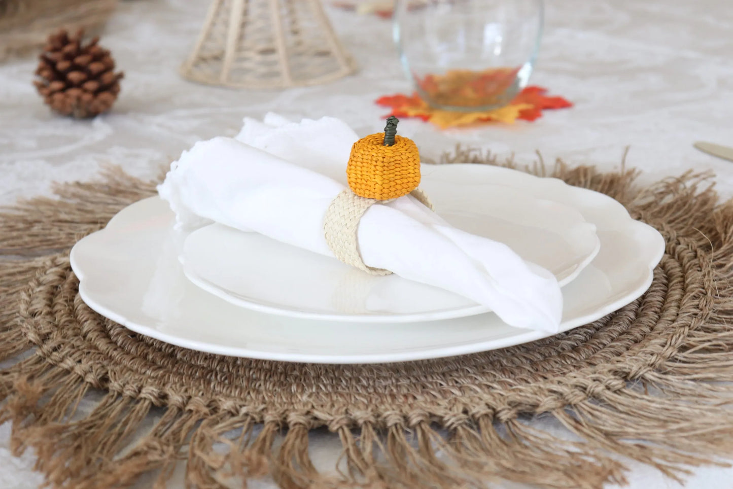 Handcrafted Pumpkin Napkin Ring made from Iraca Palm by artisans in Colombia. This charming autumn decor piece measures 2" x 1.5" and adds a festive touch to any table. Clean with a damp cloth or toothbrush to maintain its beauty.