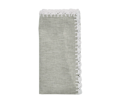 The Shell Edge napkin in gray with hand-crocheted raffia edging in white. A versatile napkin suited for bohemian and rustic-inspired table settings. 100% linen with raffia trimming.