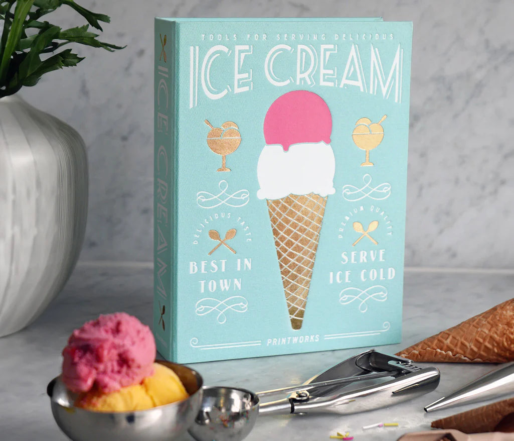 Essential Ice Cream Kit in an elegant book-like box, containing 2 cone shapes, an ice cream scoop, and 2 sprinkle scoops, all made of stainless steel and dishwasher safe. Perfect for hosting ice cream parties.