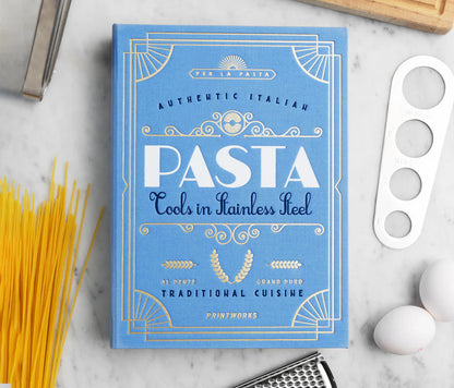 Essential Pasta Kit in an elegant book-like box containing stainless steel spaghetti measurer, serving tongs, and grater—all dishwasher safe for perfect pasta nights.