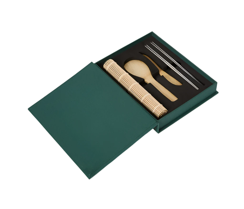 Essential Sushi Kit in a book-like box, featuring a bamboo rice paddle, spreading knife, rolling mat, and 8 chopsticks. Ideal for sushi-making, with all tools dishwasher safe.