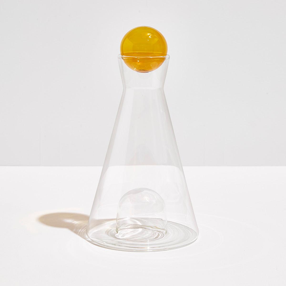 Clear and amber Vice Versa Carafe with a sculptural sphere that can rest in the glass-blown mouth or base, perfect as a centerpiece or stylish serving vessel.