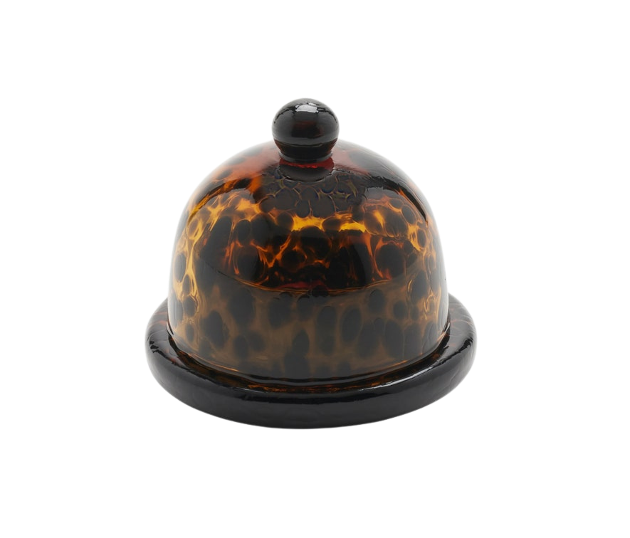 Andrew Tortoise Round Butter Dish made from hand-blown glass with a rich Tortoise finish. Measures 3 inches in diameter and 3 inches in height, adding a touch of elegance to any table. Dishwasher safe with unique variations.