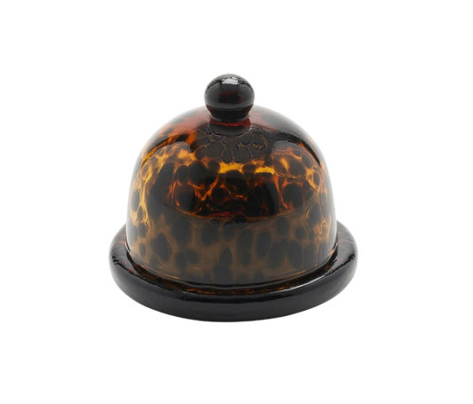 Andrew Tortoise Round Butter Dish made from hand-blown glass with a rich Tortoise finish. Measures 3 inches in diameter and 3 inches in height, adding a touch of elegance to any table. Dishwasher safe with unique variations.