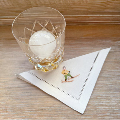 Hand-embroidered Ski Cocktail Napkins, designed in Portland, Oregon. Meticulously crafted from cotton by expert artisans, these elegant napkins are perfect for daily use and entertaining, adding a touch of sophistication to your table.